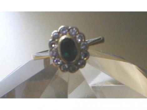 A diamond and emerald cluster ring