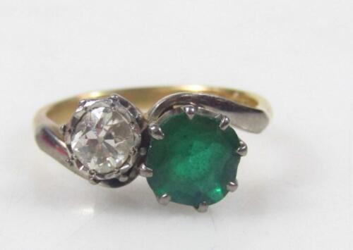 An emerald and diamond twist ring