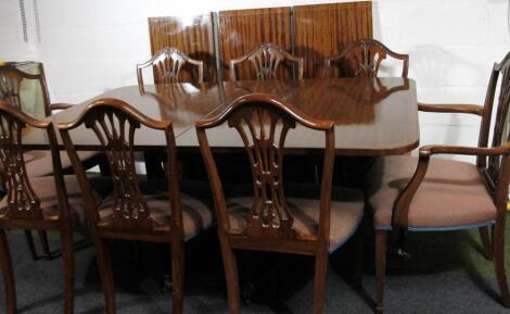 A George III style Hepplewhite design extending mahogany finish dining table and shield back chairs