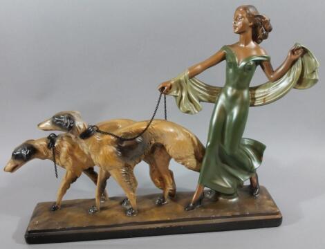 A mid 20thC Art Deco plaster figure group of a lady walking dogs