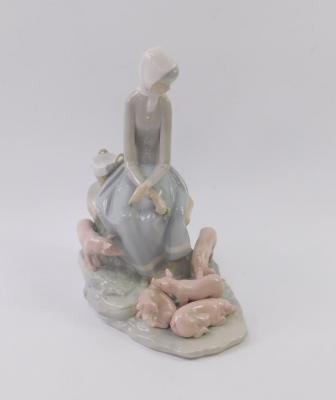 A Lladro porcelain figure of a girl with piglets