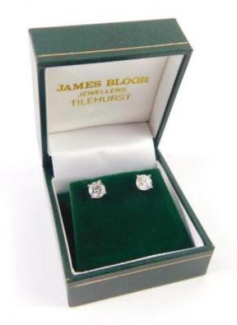 A pair of diamond solitaire earrings