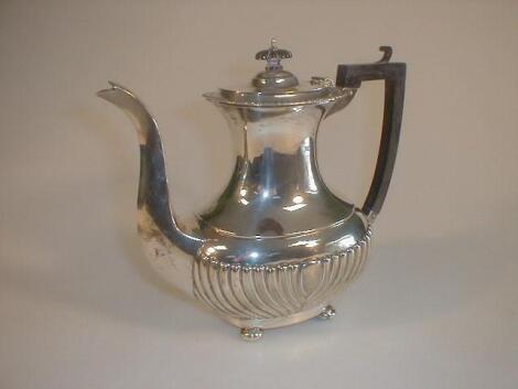 A George V silver coffee pot of part reeded form on ball feet