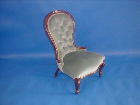 A Victorian walnut spoon back nursing chair upholstered in blue button draylon