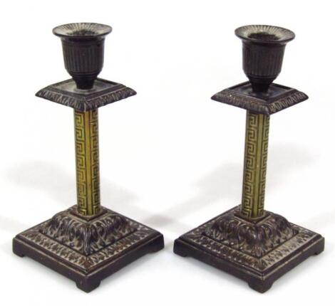 A pair of early 20thC aesthetic style metal candlesticks