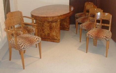 An Art Deco figured walnut dining table and six chairs (including two carvers)