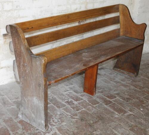 A stained oak slat back church pew