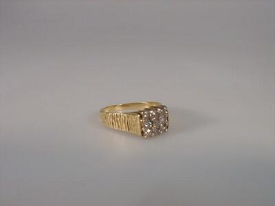 A ladies dress ring of nine tiny diamonds forming a square to bark finish