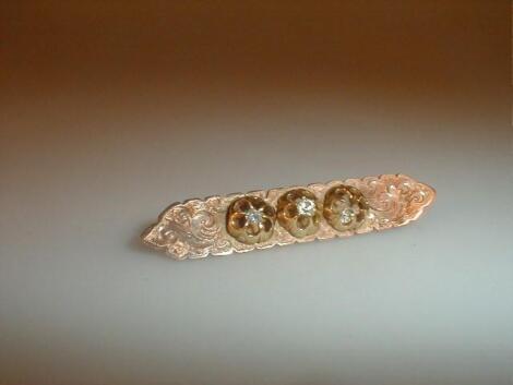 A Victorian bar brooch set with three small diamonds as flower heads (one