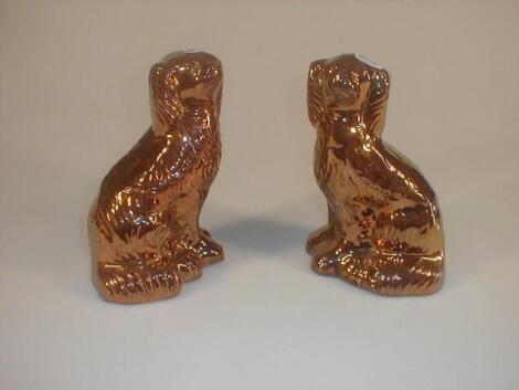 A pair of late 19thC Staffordshire pottery copper lustre seated spaniels