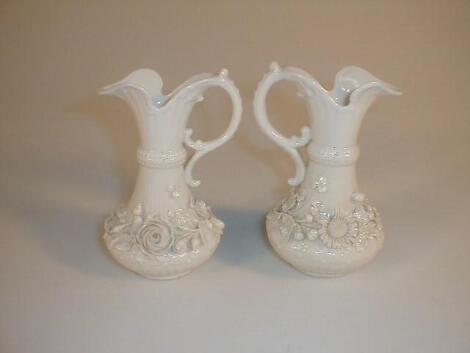 A pair of Belleek jugs of swept bellied form