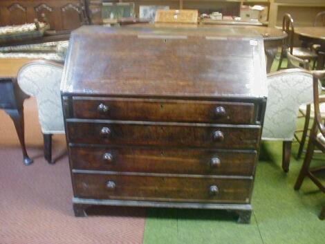 A George III mahogany cross banded oak bureau with fall flap revealing