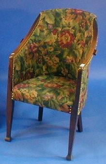 An Arts & Crafts oak tub chair with floral upholstery