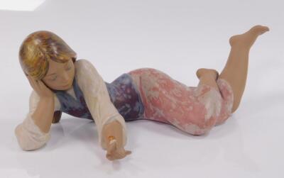 A Lladro matt porcelain figure of a girl lying down with a snail on her finger