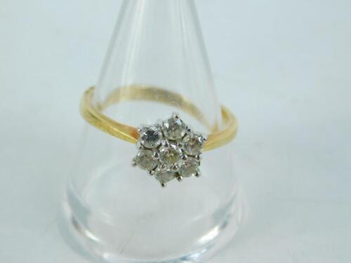 An 18ct gold and diamond six stone flower head ring