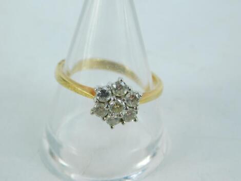 An 18ct gold and diamond six stone flower head ring