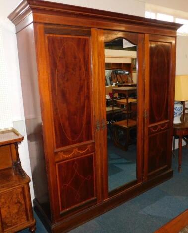 An Edwardian mahogany triple compactum wardrobe