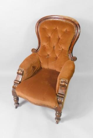 A Victorian spoon back armchair with brown button back upholstery and overstuffed seat