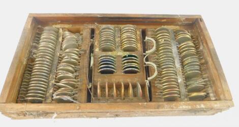 An early 20thC box of optician's testing lenses