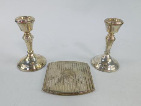 A pair of Elizabeth II silver loaded candlesticks