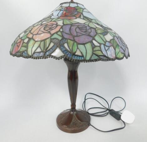 A Tiffany style table lamp with a glass shade decorated with roses.