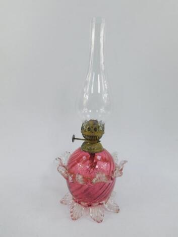 An early 20thC cranberry glass oil lamp