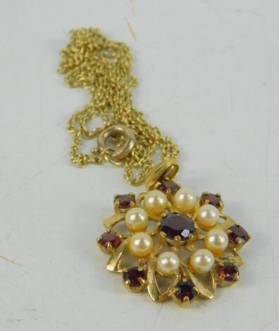 A 9ct gold garnet and seed pearl floral pendant on chain