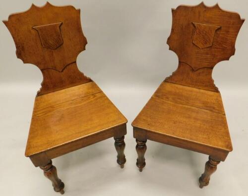 A pair of Victorian oak hall chairs