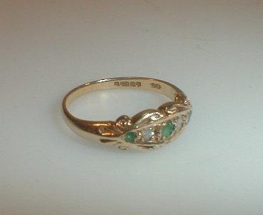 A gypsy style emerald and diamond set ring