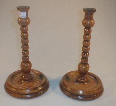 A pair of early 20thC oak bobbin turned candlesticks