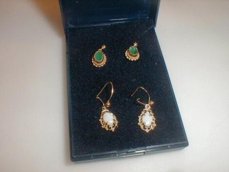 A pair of oval green stone set earrings and a pair of small opal set earrings