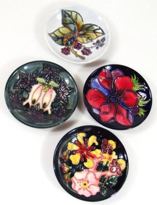 Four various Moorcroft saucers