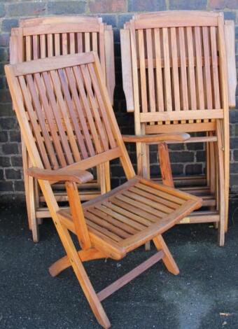 A set of eight slatted teak style oiled FSC folding patio chairs