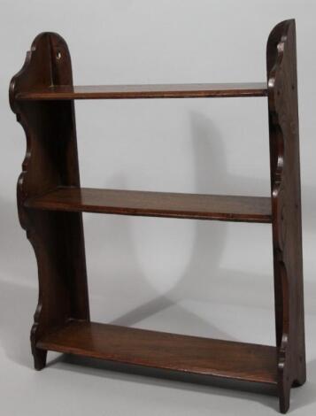 An early 20thC oak stained waterfall hanging bookcase