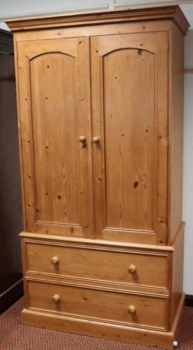 A modern stripped and lightly polished pine double wardrobe