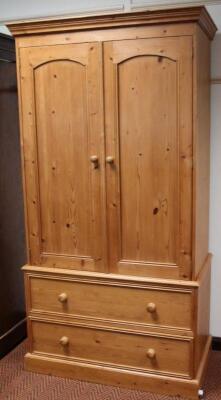 A modern stripped and lightly polished pine double wardrobe