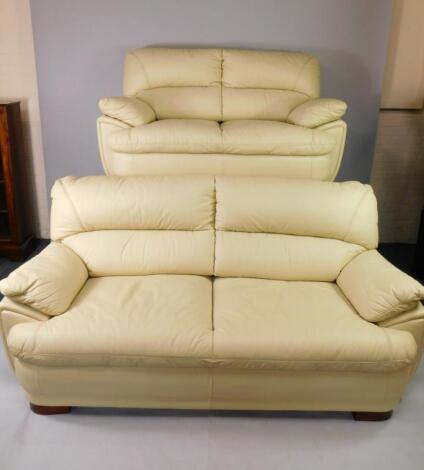 A cream leather three seater sofa and a two seater sofa