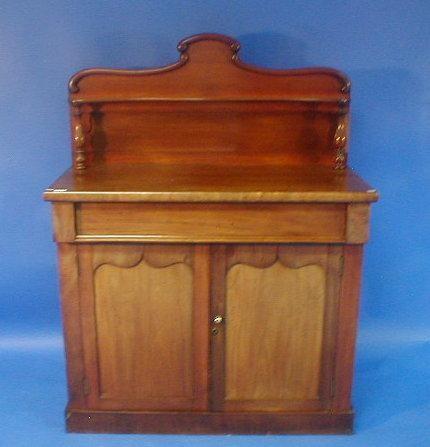 A Victorian mahogany chiffonier with shaped shelf over frieze drawer and