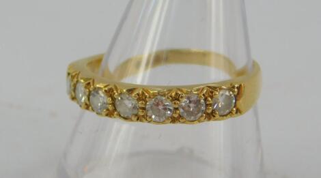 An 18ct gold and diamond seven stone half eternity ring