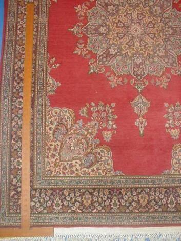 A Persian design rug with red ground centre field and floral borders