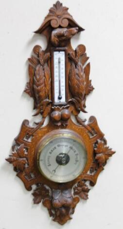 An early 20thC Black Forest style oak barometer and thermometer