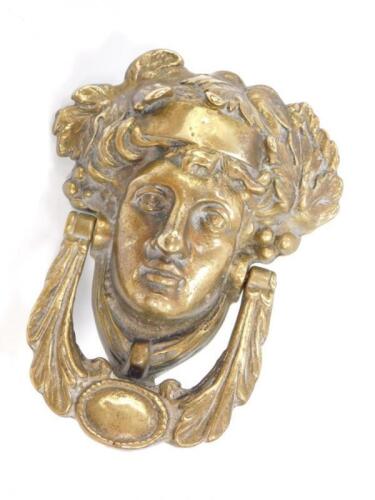 A heavy brass door knocker cast as Dionysus