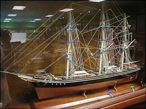 A scale model of the Cutty Sark in a modern mahogany glazed case on stand