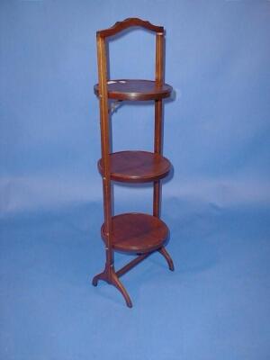 An Edwardian mahogany folding cake stand