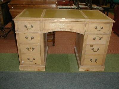 A reproduction kneehole desk with leatherette top