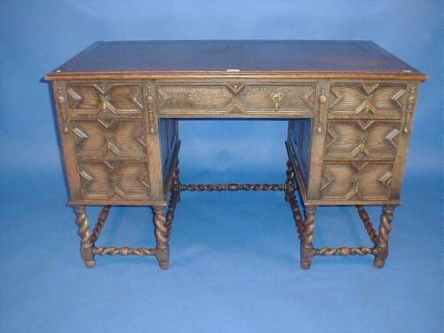 A Jacobean style oak kneehole desk with barley twist framing