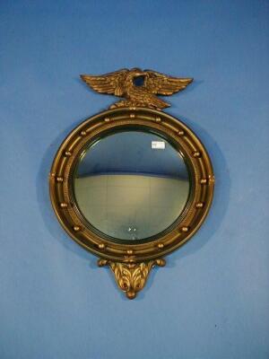 A Regency style gilt circular wall mirror with eagle mount