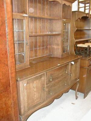 An Edwardian oak dresser with part glazed plate rack and raised on cabriole