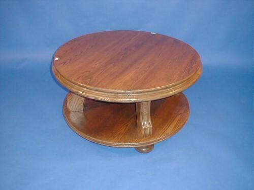 A modern oak finished circular centre table with under shelf