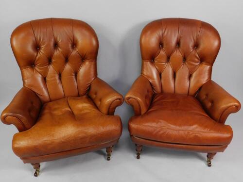 A pair of button back tan leather armchairs